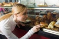 Young smiling girl gladly choosing pastry