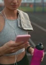 Smiling girl making sport and running in the park using her phone to listen the music with wireless headphones Royalty Free Stock Photo