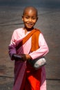 Young smiling girl monk collecting a donations on the street of Yangon, Myanmar