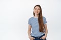 Young smiling girl in striped t-shirt. Happy teenager standing relaxed against white background Royalty Free Stock Photo