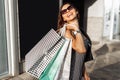 Young smiling girl in sunglasses, enjoys a successful shopping, Royalty Free Stock Photo