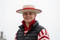 Young smiling gondolier wearing a traditional straw hat, black waistcoat and red and white striped sweater in Venice, Italy