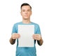 Young smiling guy dressed in a blue t-shirt holds a sheet of paper of A4 on a isolated white background Royalty Free Stock Photo