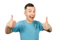 Young smiling guy, dressed in a blue t-shirt, show thumbs up on a isolated white background Royalty Free Stock Photo