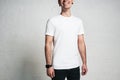 Young smiling guy in white blank t-shirt, horizontal studio port