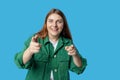 Young smiling happy fun woman point index finger camera on you say do it motivate isolated on blue background, studio Royalty Free Stock Photo