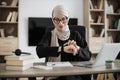 Young smiling happy successful employee muslim business woman in hijab looking at smartwatch Royalty Free Stock Photo