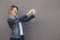 Young smiling hipster woman taking selfie with her smartphone. Gray background, copy space