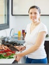 Young smiling housewife with raw seafood Royalty Free Stock Photo