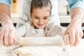 young smiling kid with her father rolling out dough Royalty Free Stock Photo