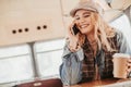 Young smiling lady talking by phone in bus cafe Royalty Free Stock Photo