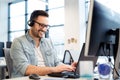 Young smiling male call center operator doing his job with a headset.Portrait of call center worker at office. Royalty Free Stock Photo