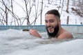 Young smiling male having fun while swimming in an ice pool on a winter day Royalty Free Stock Photo