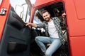 Young smiling male truck driver inside his red cargo truck Royalty Free Stock Photo