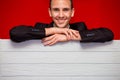 Young smiling man with blank red sign board. Handsome businessman holding banner with copyspace for advertising messages Royalty Free Stock Photo