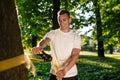 Young smiling man in the forest practising slacklining