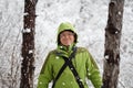 Young smiling man in glasses and green sports jacket with hood s