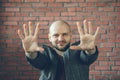 Young smiling man with hands in air to say stop or hypnotist gesture