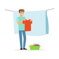 Young smiling man hanging wet clothes out to dry, house husband working at home vector Illustration
