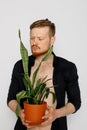 A young smiling man holds in his hands a small flower Royalty Free Stock Photo