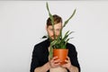 A young smiling man holds in his hands a small flower Royalty Free Stock Photo