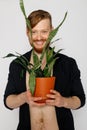 A young smiling man holds in his hands a small flower Royalty Free Stock Photo