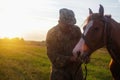 Young smiling man and horse. Loving tender moment between man and horse. Horse nose caress. Nature meadow background Royalty Free Stock Photo