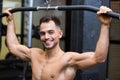 young smiling man lifting weights in gym Royalty Free Stock Photo