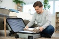 young smiling man packing clothes into travel bag Royalty Free Stock Photo