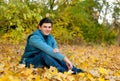 Young smiling man relaxing in autumn park.