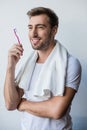 Young smiling man standing with towel on his shoulders and toothbrush Royalty Free Stock Photo