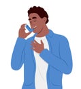 Young smiling man uses an asthma inhaler against attack. World asthma day. Bronchial asthma. Allergy, asthmatic