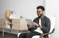 Young smiling man using digital tablet computer at home, Leisure, relaxation, online learning, web chat concepts