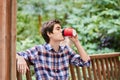 Man in the forest in wooden summerhouse with red paper cup Royalty Free Stock Photo