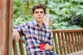 Man in the forest in wooden summerhouse with red paper cup Royalty Free Stock Photo