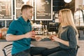Young smiling man and woman together talking in coffee shop sitting near bar counter, couple of friends drinking tea, coffee Royalty Free Stock Photo
