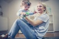 Young smiling mother have play with her son.