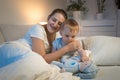 Young smiling mother hugging her baby son before going to sleep Royalty Free Stock Photo