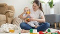 Young smiling mother playing with her baby son in toy cars at home. Concept of family having time together and children Royalty Free Stock Photo