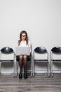 Young smiling office worker woman sitting on wood floor chair using mobile laptop computer prepare interview meeting file in offic Royalty Free Stock Photo