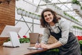 Young smiling people florist writing something while working in the garden centre or flower shop Royalty Free Stock Photo