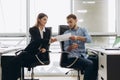 Young smiling personal assistant giving document to office worker in his office, female accountant reporting great work to ceo, Royalty Free Stock Photo