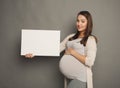 Young pregnant woman with blank white paper Royalty Free Stock Photo