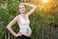 Young smiling pregnant woman. Blue little footprint drawing on belly. Pregnant concept