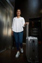 Young smiling pretty caucasian woman with suitcase going in hall in modern hotel Royalty Free Stock Photo