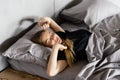 Young smiling pretty lady lies in bed indoors. Eyes closed Royalty Free Stock Photo