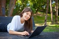 Young smiling pretty student woman, lying on the bench in park Royalty Free Stock Photo