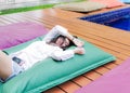 Young smiling pretty woman relaxing on waterbed of Hotel pool terrace