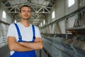 Young smiling professional in overalls and protective helmet standing in front of camera inside large machinebuilding plant Royalty Free Stock Photo