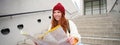 Young smiling redhead girl, tourist sits on stairs outdoors with city paper map, looking for direction, traveller Royalty Free Stock Photo